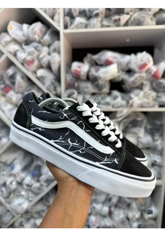black and white Vans Old Skool sneakers with a white lightning design